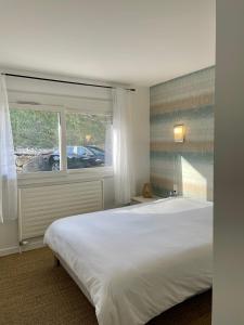 勒伯吉特杜拉克CAMP DE BASE SUR LE LAC DU BOURGET的卧室设有一张白色大床和一扇窗户。