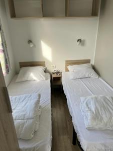 米德尔克尔克Luxe stacaravan的配有白色床单的客房内的两张床