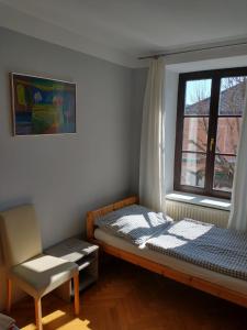 盖布利茨Ferienwohnung Madlene 2的卧室配有床、椅子和窗户。