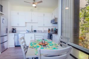 唯客乐渡假村Waikoloa Villages E108的厨房配有桌子、白色橱柜和桌椅
