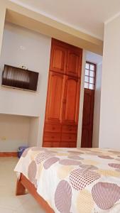 塔拉波托Rosa Victoria的一间卧室配有一张床和一个木制橱柜