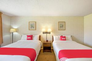 多斯韦尔OYO Hotel Doswell Kings Dominion的两张位于酒店客房的床,配有红色和白色枕头
