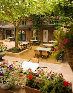 富伦Vakantiewoningen-Pizzeria Blanckthys Voeren的户外庭院设有桌椅和鲜花