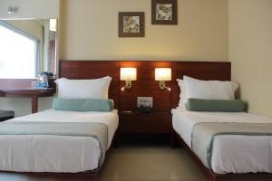奥兰加巴德绿橄榄酒店的酒店客房设有两张床和一张桌子。