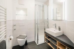 诺德奈Apartmenthaus B3的白色的浴室设有卫生间和水槽。