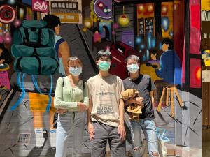 台南mydeer backpacker的三人身着面具站在壁画前