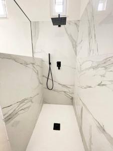 莫诺波利DAVID HOUSE的一间设有白色大理石墙壁和淋浴的浴室
