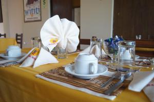奇瓦伊Sumac wasi的一张桌子,上面有黄色的桌布,上面有盘子和银器