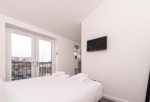 诺丁汉Cricket View - Fabulous 1bed Apt near Trent Bridge Cricket Ground的白色的房间,设有床铺和墙上的电视