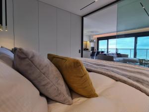 济夫努夫BALTIC VIEW Luxury Apartment Gardenia FRONT的一间卧室配有带枕头的床,一间客厅