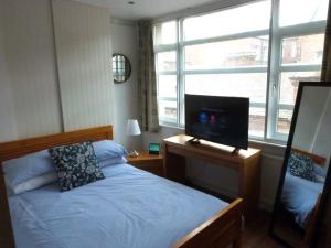 泰恩河畔纽卡斯尔Lovely 2 bed flat in the VERY CENTRE of Newcastle的一间卧室配有一张床和一张桌子,上面配有电脑