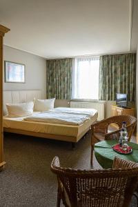 Neubukow瓦德施罗森欧纽不布科酒店的卧室配有一张床和一张桌子及椅子