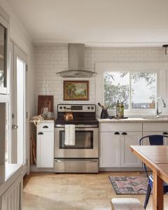 WaupoosGran Roble的厨房配有不锈钢炉灶和白色橱柜。