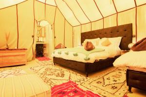 AdrouineSunset luxury camp的帐篷内一间卧室,配有一张床