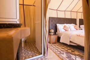 AdrouineSunset luxury camp的卧室配有1张床、浴缸和镜子