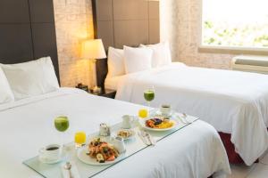 危地马拉Adriatika Hotel & Residence的一间酒店客房,配有两张床和一盘食物