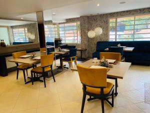 波哥大Hotel Retiro 84 by MIJ的一间带桌椅和蓝色沙发的餐厅