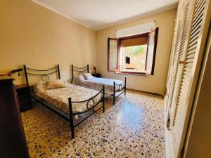 塔拉莫内Da Allegro al mare的一间卧室设有两张床和窗户。