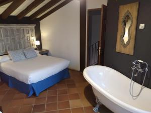 HitaSpa La Cueva del Agua的一间卧室配有一张床、一个浴缸和一张床