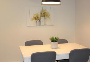 惠灵顿County Cove - Wellington Suite的一张带椅子的白色桌子和一株植物