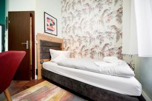 柏林AMC Hotel - Schöneberg的一间卧室配有一张带花卉壁纸的床