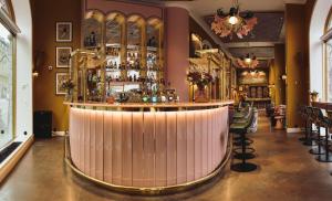 斯德哥尔摩Hotel Kung Carl, WorldHotels Crafted的餐厅的酒吧,有粉红色窗帘