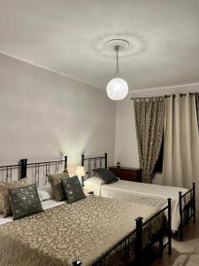 瓦尔法布里卡区弗朗西斯科苏伊帕西宾馆的一间卧室配有两张床和吊灯。