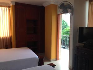 巴耶杜帕尔Hotel Vans Valledupar的一间卧室配有一张床、一台电视和一个阳台
