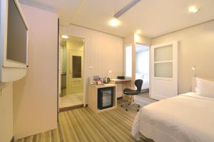 台北优美饭店-双连MRT的酒店客房配有一张床、一张桌子和一把椅子。