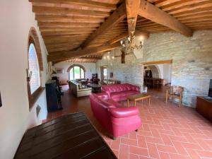 基亚恩尼Belvilla by OYO Podere San Giovanni ventisei的客厅配有红色家具和石墙