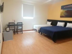 利马Miraflores Rooms的一间卧室配有两张床和一张桌子及椅子