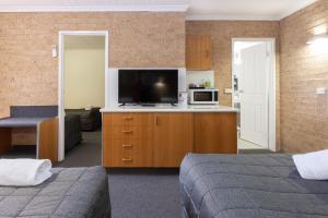 阿米代尔雪松小屋汽车旅馆的酒店客房设有两张床和一台平面电视。