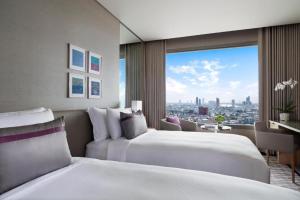 曼谷曼谷安凡尼+河畔酒店的酒店客房设有两张床和大窗户。