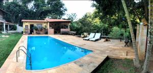 帕蒂杜阿尔费里斯Casa de campo com piscina em Paty do alferes的一座房子后院的游泳池