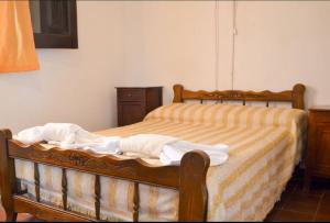 米娜克拉韦罗阿圭罗全新酒店的一间卧室配有一张带黄白色床单的木床