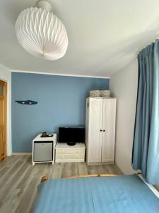 韦巴Pokoje gościnne EWELA的一间拥有蓝色墙壁的卧室、一张床和橱柜