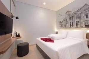 当格浪Azana Style Hotel Bandara Jakarta的卧室配有白色的床和电视。