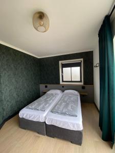 佐伊杜比斯特布腾普拉特兰格维克旅馆的一间卧室配有一张带绿色墙壁的床