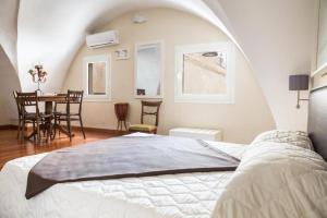 加利波利Faro Bianco Gallipoli - Suites & Apartments的一间卧室配有一张床,另一间用餐室配有桌子
