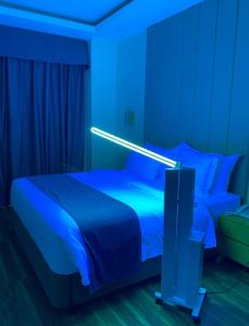 TanauanBravo Tanauan Hotel的一间卧室配有一张蓝色灯床