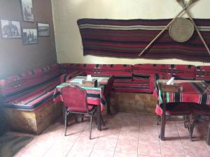 马达巴Queen Ayloa Hotel&Restaurant的一间餐厅,房间内设有红色的桌椅