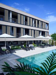 尼基季ANASSA BUTIK LIVING NIKITI的一个带游泳池和遮阳伞的酒店