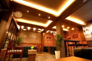 安加马尔伊ORFILA INN Airport Hotel的一间设有酒吧的餐厅,拥有砖墙