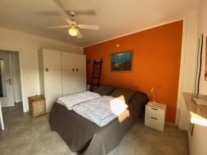 格拉多Anfora MitoMare的一间卧室设有一张床和橙色的墙壁