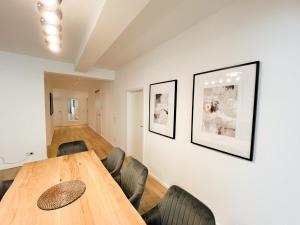 杜塞尔多夫Centerapartments Premium DeLuxe的一间带木桌和椅子的用餐室