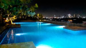 KebonnanasVentura Room at TreePark City的夜间带蓝色灯光的大型游泳池