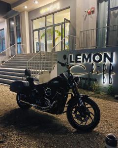 北马马亚-讷沃达里Lemon Cliff Luxury B&B的停在大楼前的一辆黑色摩托车