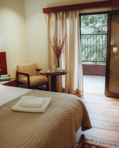 普拉特斯Kallithea INN的一间卧室配有一张桌子和一个阳台。