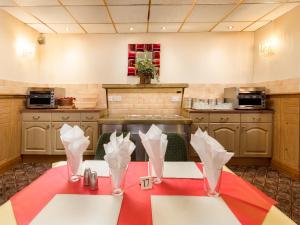 布莱克浦Oak Lea Hotel的厨房配有一张带红色桌布的桌子