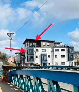 巴洛赫Riverside View Penthouse in Balloch, Loch Lomond的上面有两只红箭头的建筑
